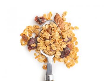 Spoon with granola on white background�