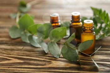 Bottles of eucalyptus essential oil on wooden table�