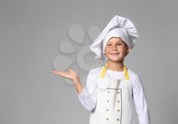 Cute little chef on grey background�