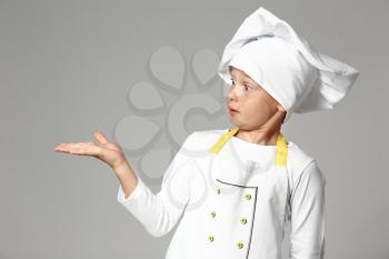 Cute little chef on grey background�