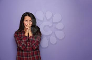 Stressed young woman on color background�