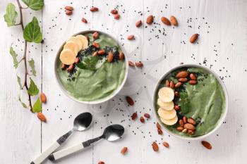 Bowls with tasty spirulina smoothie on white table�