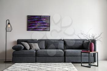 Stylish interior of living room with comfortable grey sofa�