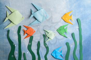 Composition with origami fishes on color background�