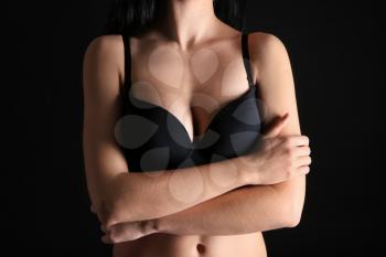 Young woman with beautiful breast on dark background�