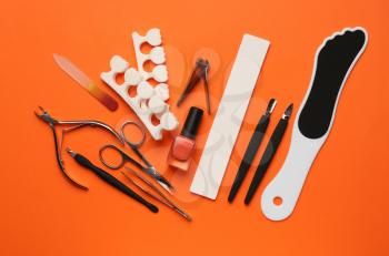 Set of professional tools for pedicure on color background�