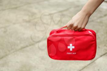 Woman with first aid kit outdoors�