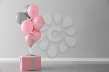 Birthday balloons with gift box in room�