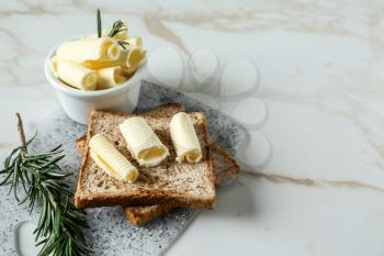 Tasty toasts with butter curls on table�