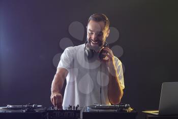 Male DJ playing music in club�