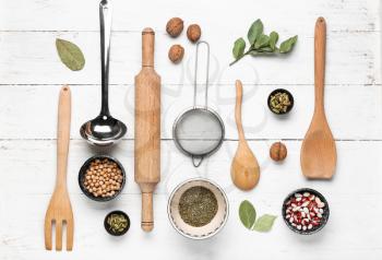 Set of kitchenware and spices on white wooden background�