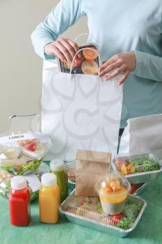 Worker of food delivery service packing order for customer�