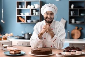 Male confectioner with tasty chocolate cake in kitchen�