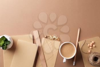 Stylish stationery with cup of coffee on color background�