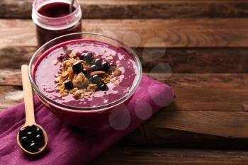 Bowl with tasty acai smoothie on wooden table�