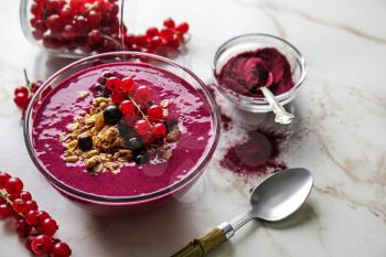 Bowl with tasty acai smoothie on light table�
