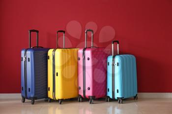Packed suitcases near color wall�