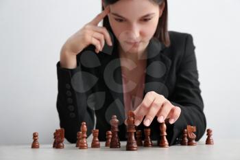 Businesswoman playing chess at table. Concept of developing strategy for career growth�