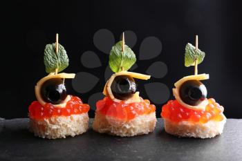 Tasty canapes on dark background�