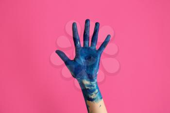 Painted female hand on color background�