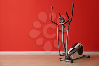 Modern exercise machine near color wall�
