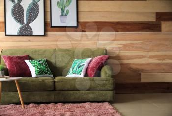 Soft couch near wooden wall in interior of living room�