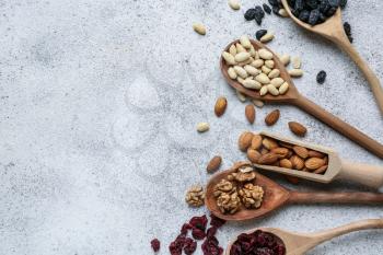 Assortment of tasty dried fruits and nuts on grey background�