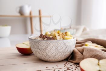 Bowl with tasty sweet oatmeal on wooden table�