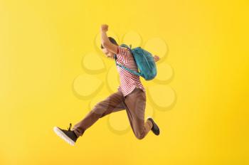 Portrait of jumping African-American teenage boy on color background�