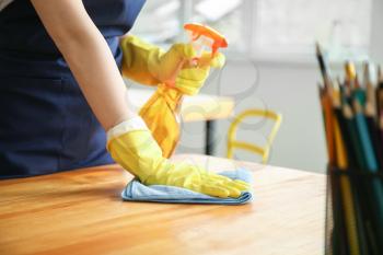 Female janitor cleaning table in office, closeup�