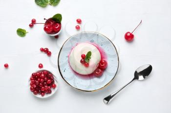 Plate with tasty panna cotta on white table�