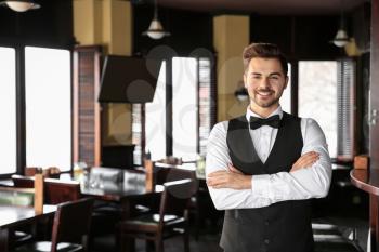 Young male waiter in restaurant�