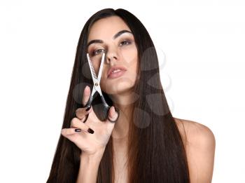 Portrait of beautiful young woman with healthy long hair and scissors on white background�