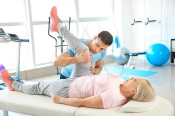 Physiotherapist working with mature patient in rehabilitation center�