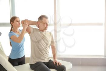 Physiotherapist working with mature patient in rehabilitation center�
