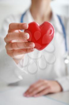 Cardiologist with red heart in clinic, closeup�