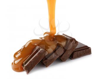 Pouring of liquid caramel onto chocolate on white background�