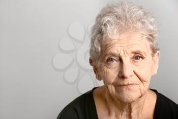 Portrait of senior woman on grey background�