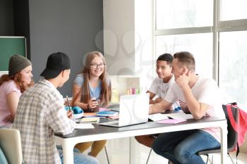 Group of teenagers studying together in school�
