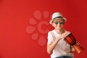 Teenage boy playing drum against color background�