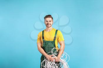 Male electrician on color background�