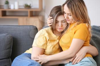 Mother calming her sad daughter at home�