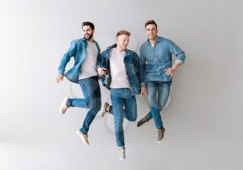 Jumping young men on light background�