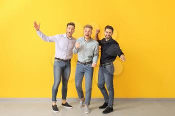 Happy young men near color wall�