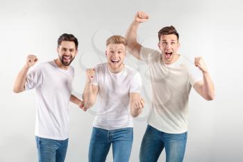 Happy young men on light background�