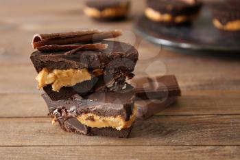 Tasty chocolate peanut butter cups on wooden table�