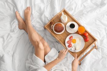 Woman having tasty breakfast in bed�