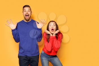 Excited young couple on color background�