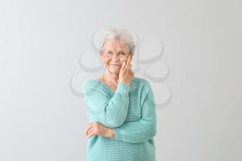 Portrait of senior woman on light background�