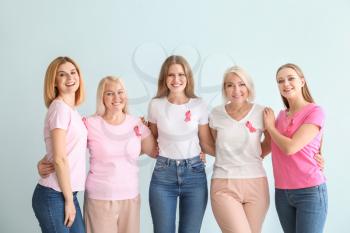 Beautiful women of different ages with pink ribbons on light background. Breast cancer concept�